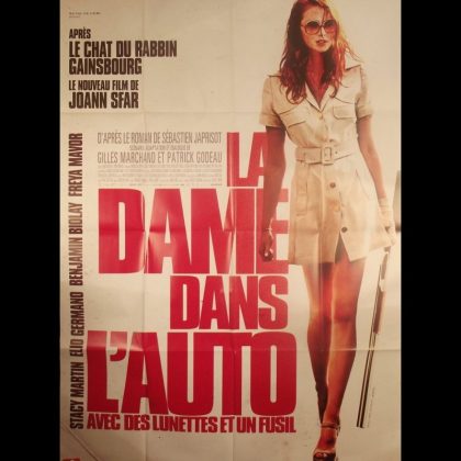 LA DAME DANS L'AUTO AVEC DES LUNETTES ET UN FUSIL